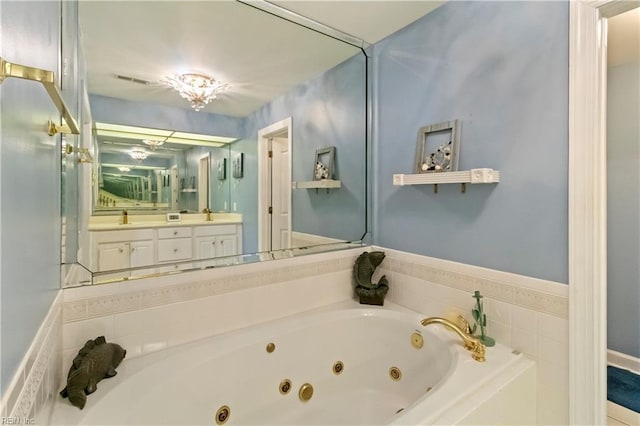 bathroom featuring tiled tub and sink