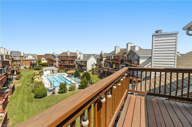 wooden terrace with a community pool and a lawn