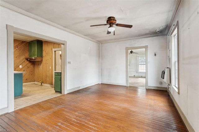 empty room featuring ornamental molding, heating unit, and light hardwood / wood-style flooring