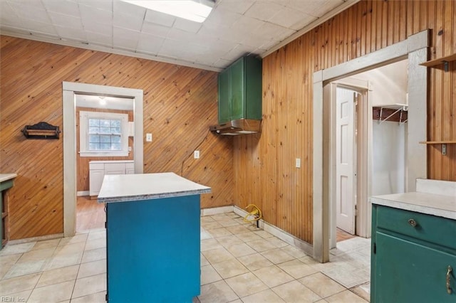 interior space with a kitchen island, light tile patterned floors, and green cabinetry