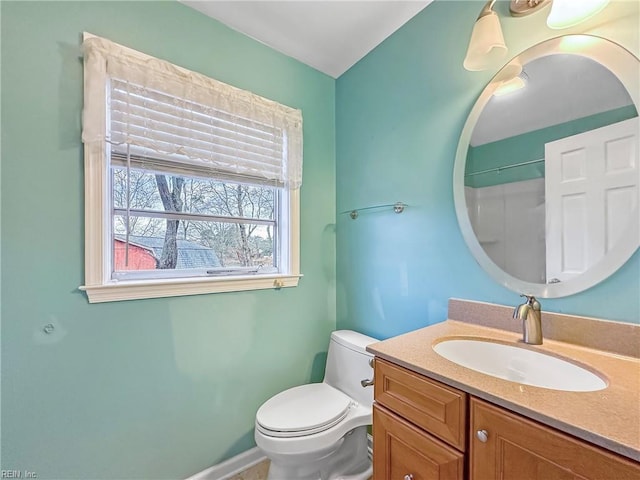 bathroom with vanity, a shower, and toilet