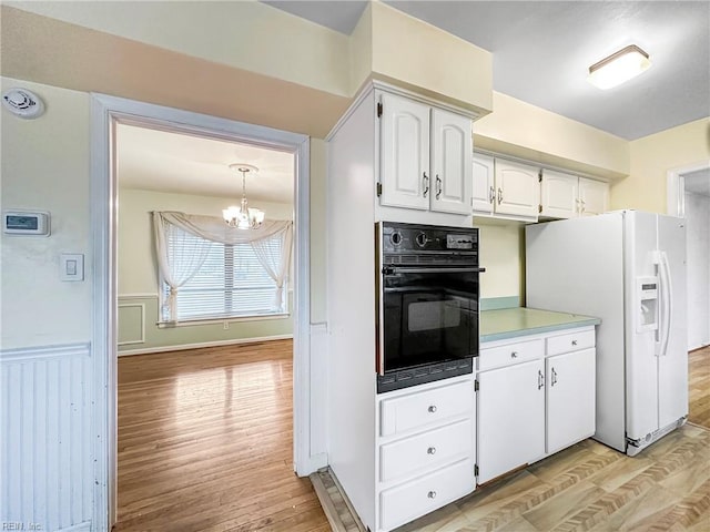 kitchen featuring decorative light fixtures, white cabinetry, oven, white fridge with ice dispenser, and light hardwood / wood-style flooring