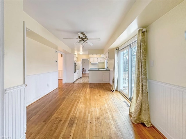 unfurnished living room featuring light hardwood / wood-style flooring and ceiling fan