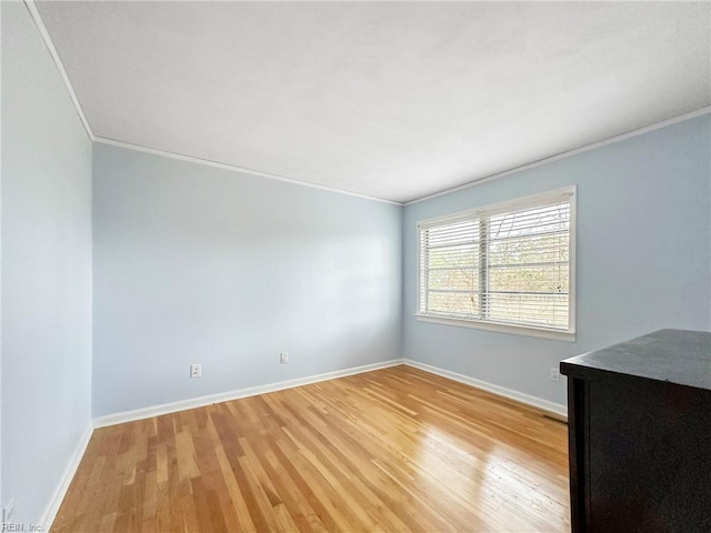 empty room featuring crown molding and light hardwood / wood-style flooring