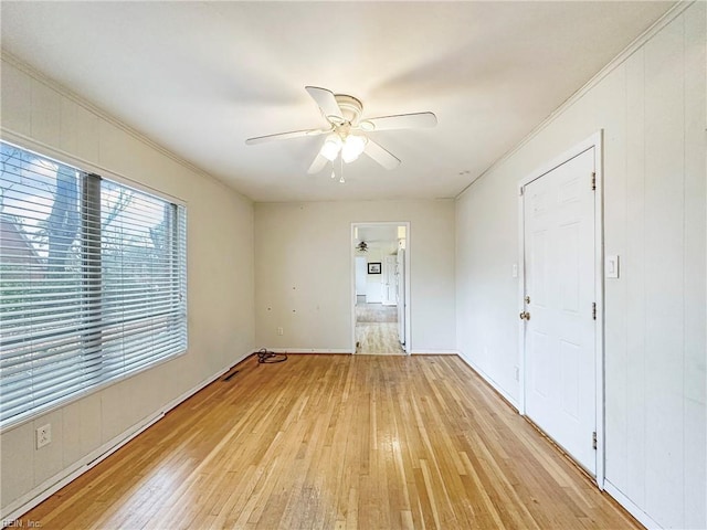 spare room featuring ornamental molding, ceiling fan, and light wood-type flooring