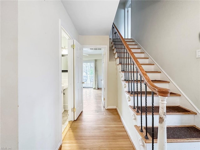 staircase with hardwood / wood-style floors