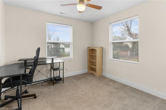 carpeted office space featuring ceiling fan