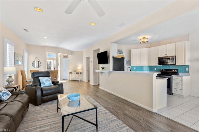 living room with ceiling fan and light wood-type flooring