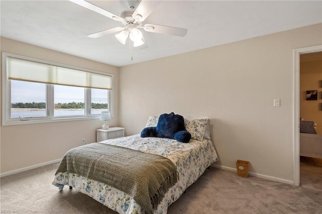 bedroom featuring light colored carpet and ceiling fan