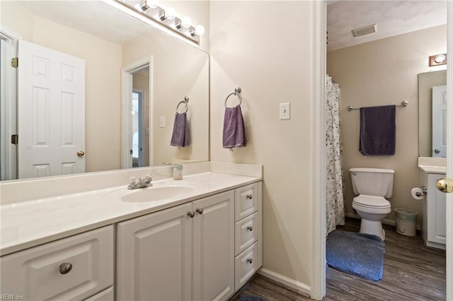 bathroom with vanity, toilet, and hardwood / wood-style floors