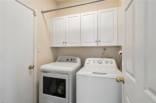 washroom featuring cabinets and washing machine and dryer