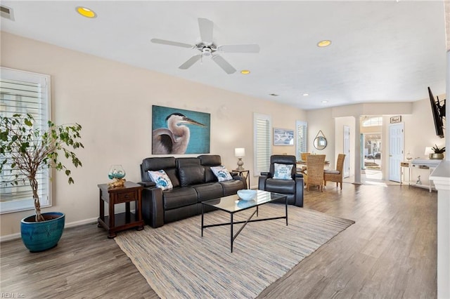 living room featuring hardwood / wood-style floors and ceiling fan