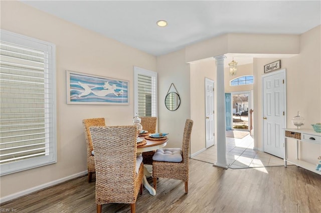 dining room with light hardwood / wood-style flooring and ornate columns