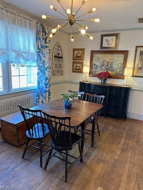 dining area featuring radiator and hardwood / wood-style flooring