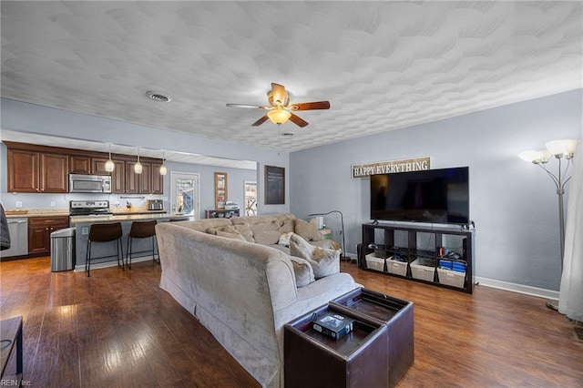 living room featuring dark wood-type flooring and ceiling fan