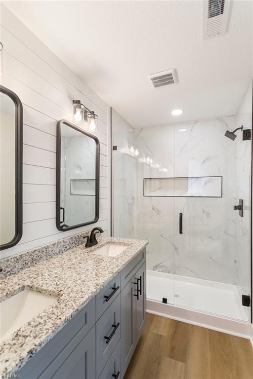 bathroom with hardwood / wood-style flooring, vanity, and a shower with shower door