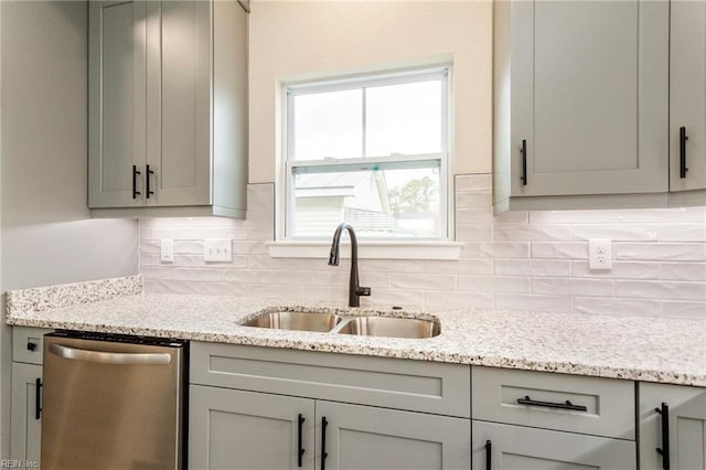 kitchen with dishwasher, sink, gray cabinetry, and light stone counters