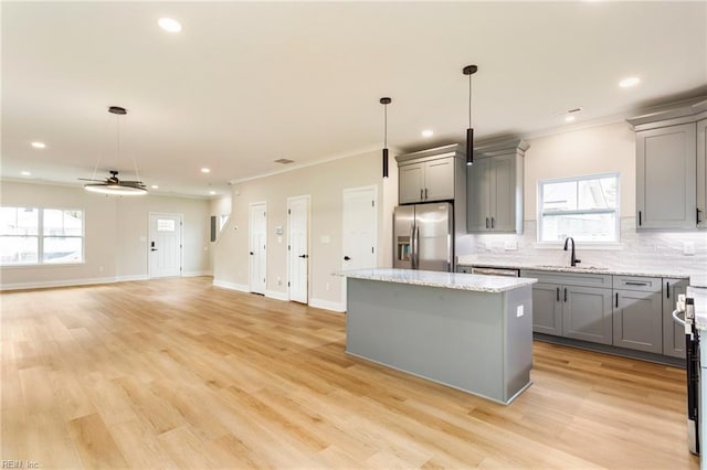 kitchen featuring a kitchen island, pendant lighting, sink, gray cabinetry, and stainless steel refrigerator with ice dispenser