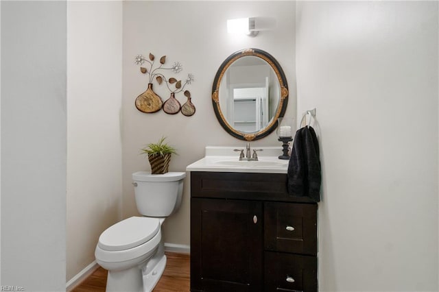 bathroom featuring vanity, hardwood / wood-style flooring, and toilet