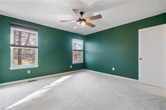 spare room with carpet floors, a textured ceiling, and ceiling fan