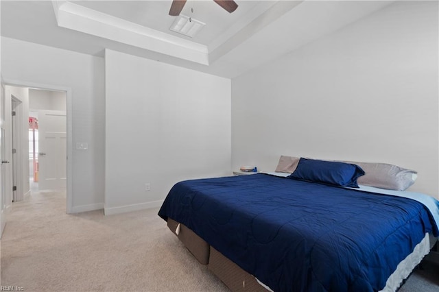 bedroom with ceiling fan, a raised ceiling, and light carpet