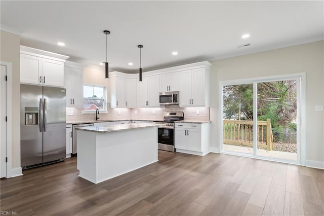 kitchen with stainless steel appliances, pendant lighting, and white cabinets