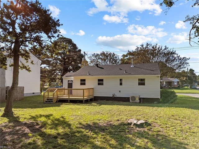 rear view of property featuring a deck, a lawn, and ac unit