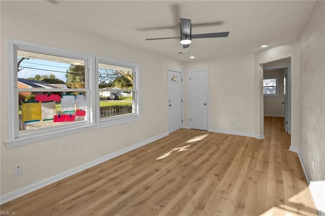 spare room featuring ceiling fan, a healthy amount of sunlight, and light hardwood / wood-style floors