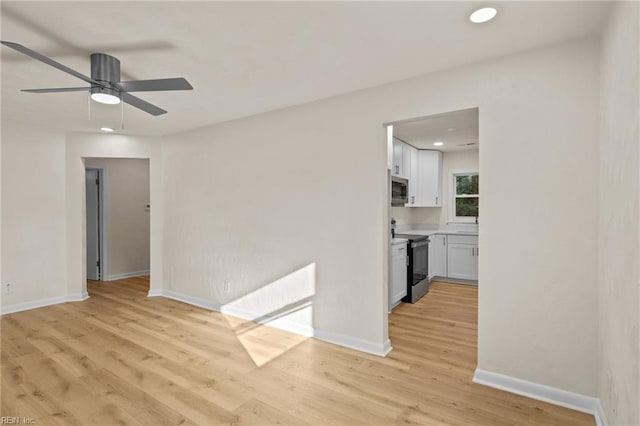 unfurnished room with ceiling fan and light hardwood / wood-style flooring