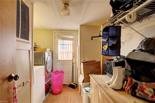 clothes washing area with separate washer and dryer, hardwood / wood-style floors, and a textured ceiling