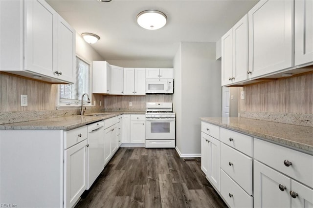 kitchen featuring sink, backsplash, white cabinets, light stone counters, and white appliances