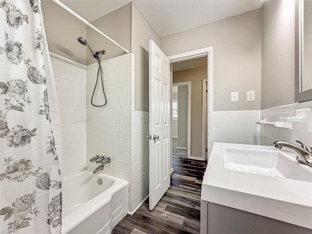 bathroom with tile walls, vanity, hardwood / wood-style floors, and shower / bath combination with curtain