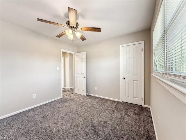 unfurnished bedroom featuring ceiling fan and dark carpet