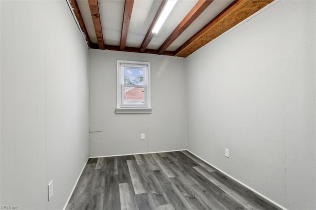 empty room featuring beam ceiling and hardwood / wood-style floors