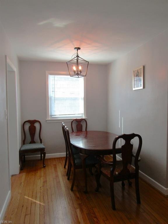 dining area featuring an inviting chandelier and light hardwood / wood-style flooring