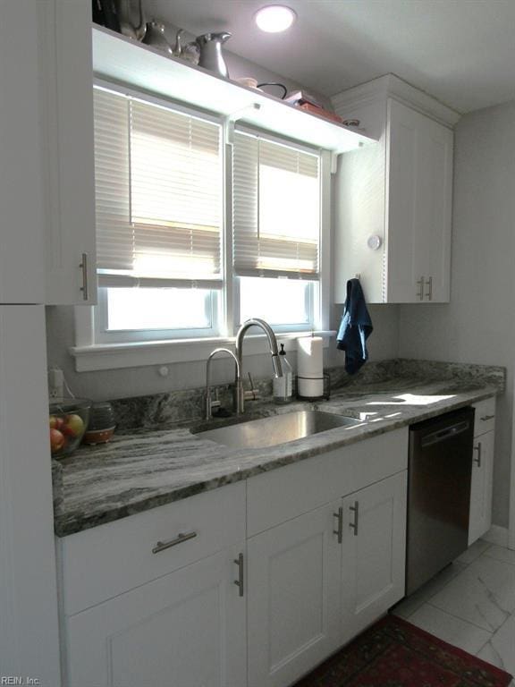 kitchen featuring white cabinetry, sink, stainless steel dishwasher, and a healthy amount of sunlight