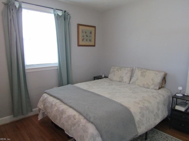 bedroom with dark wood-type flooring