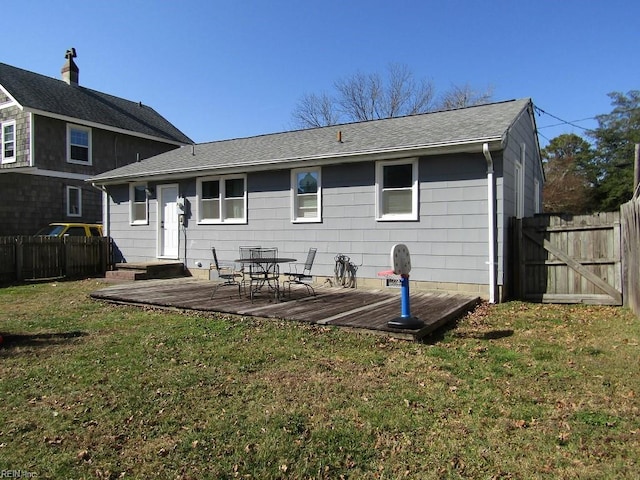 back of property featuring a lawn and a deck