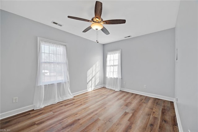 empty room with ceiling fan and light hardwood / wood-style flooring