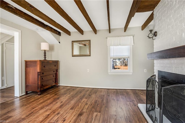 living room featuring beam ceiling, a large fireplace, and dark hardwood / wood-style flooring