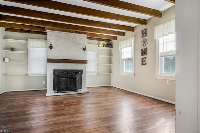 unfurnished living room featuring beamed ceiling, a large fireplace, and dark hardwood / wood-style flooring