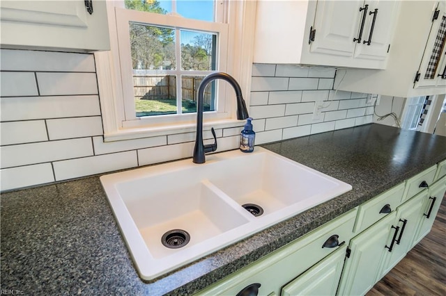 room details with white cabinetry, sink, and tasteful backsplash