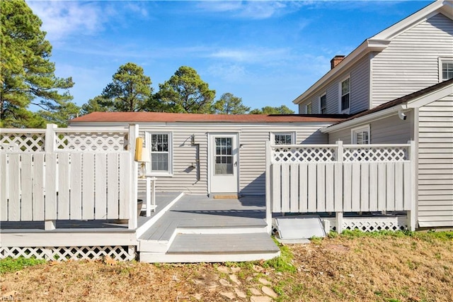 rear view of property featuring a wooden deck