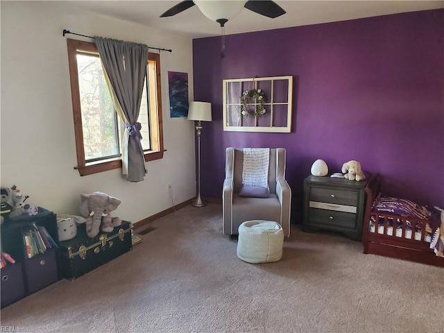 sitting room with ceiling fan and carpet flooring