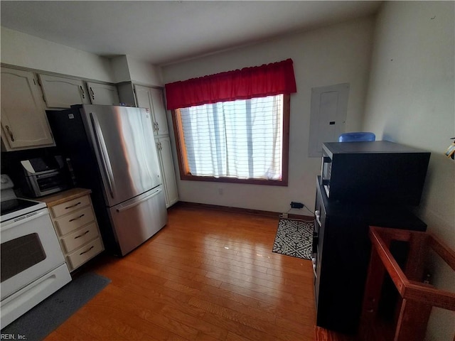 kitchen with white cabinetry, light wood-type flooring, stainless steel fridge, white electric stove, and electric panel