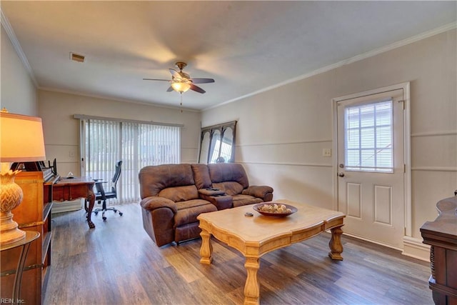 living room with wood-type flooring, ornamental molding, and plenty of natural light