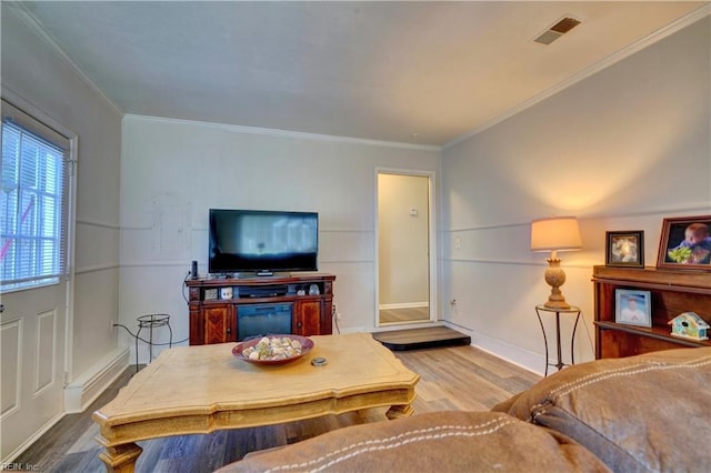 living room featuring wood-type flooring and ornamental molding