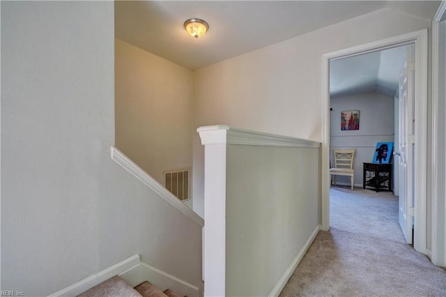 hallway with light carpet and vaulted ceiling