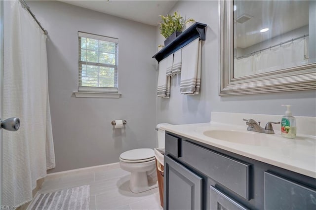 bathroom featuring tile patterned floors, vanity, and toilet