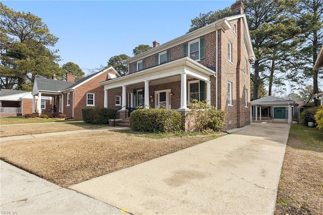 view of front of house featuring an outbuilding, a porch, a garage, and a front yard